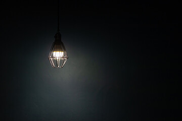 Light bulb warm light shade on dark background, concept of creativity and innovation.