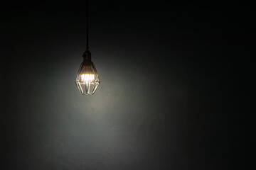 Light bulb warm light shade on dark background, concept of creativity and innovation.