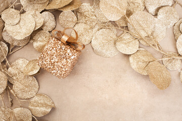 Sparkling festive background, shimmering gold leaves and ornaments. Gift and mushroom

