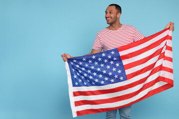 4th of July - Independence Day of USA. Happy man with American flag on light blue background, space...