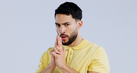 Finger gun, serious and portrait of man in studio with aim for target, shooting and spy on blue...