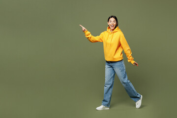 Full body side view surprised shocked fun young Latin woman wearing yellow hoody casual clothes...