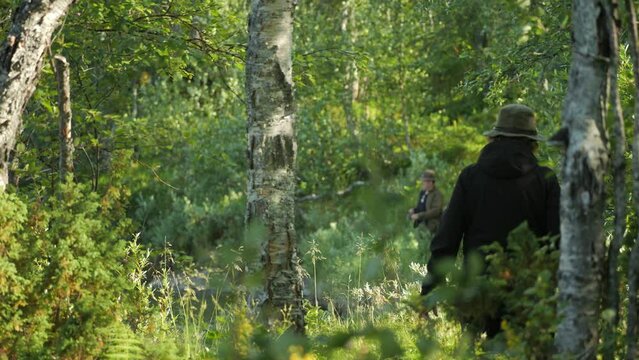 Senior couple fishing in a lake in the forest. Daylight. Static view