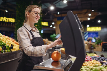 Side view young smiling happy seller cashier woman wearing uniform working at supermaket store...