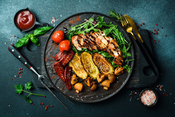 Grilled chicken fillet with grilled vegetables on a plate. Barbecue menu. On a dark background,...