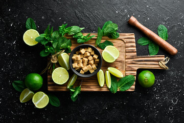 Bar banner with the preparation of a cooling mint cocktail. Mojito: lime, mint and brown sugar. On a black background. Top view.