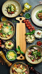 A set of food and dishes in plates. Top view. Food banner. On a dark stone background.