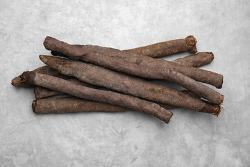 Raw salsify roots on grey table, flat lay