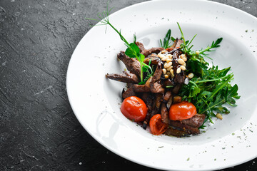 Fresh salad with veal: arugula, veal, pine nuts and eggplant. Healthy food. On a white plate....