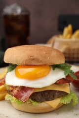 Delicious burger with fried egg on table, closeup