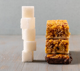 A stack of cereal bars and a stack of cubed sugar next to each other