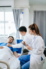 Obraz premium Two doctors talking to a patient lying in his bed with receiving saline solution in hospital .