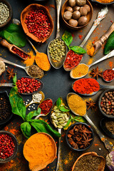 Set of Indian colored spices and seasonings in spoons. Vertical photo. Top view.