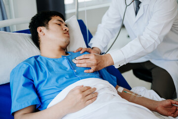 Two doctors talking to a patient lying in his bed  with receiving saline solution