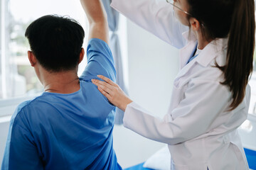 Female Doctor and patient suffering from back pain during medical exam.