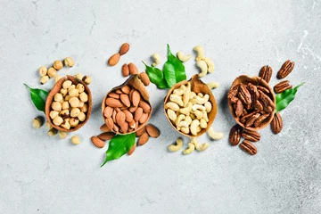 Fotobehang a set of nuts in a bowl on a light stone background. Healthy snacks. Nuts © Yaruniv-Studio