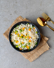 Authentic Chinese and Asian fried rice with egg and vegetables in ceramic brown bowl top view .Traditional dish of China with space for text.