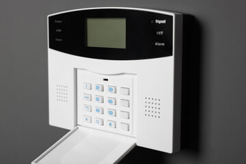 Home security alarm system on gray wall, closeup