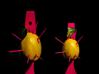 Composition with two lemons and arrows on a black background