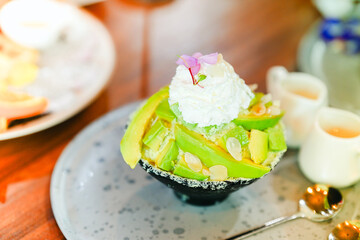 Green avocado bingsu on the dining table in a cafe.
