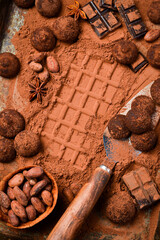 Sweet chocolate truffles with cocoa powder. On a dark chocolate background. Cocoa beans.