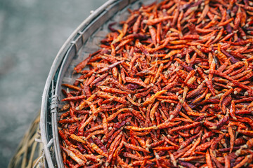 Ripe red chilies that are dried in wooden baskets to be used as a seasoning in food in Thailand.