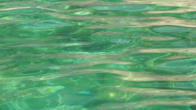 Sea water surface. Low angle view over clear azure sea water. Sun glare. Abstract nautical summer ocean nature. Holiday, vacation and travel concept. Nobody. Slow motion. Weather and climate change