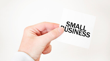 Businessman holding a card with text SMALL BUSINESS, business concept