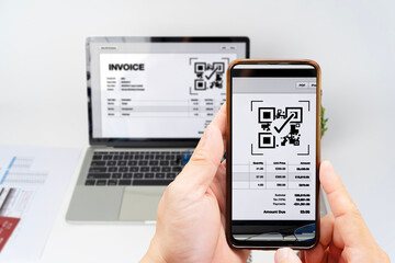 Woman scanning QR code from invoice to make payment using fast secure payment system and smartphone...