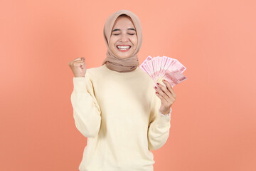 holding cash money in Indonesian rupiah banknotes