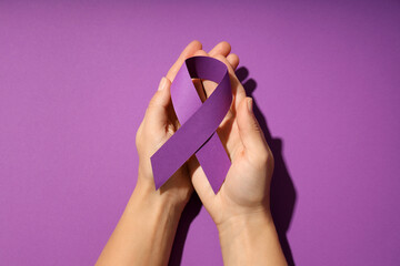 The concept of eliminating violence against women purple ribbon in hands - obrazy, fototapety, plakaty