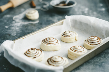 Raw, unbaked cinnamon buns resting. Cooking of healthy buns from alternative flours. Vegan bread. Festive food