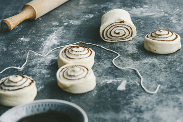Raw, unbaked cinnamon buns resting. Cooking of healthy buns from alternative flours. Vegan bread. Festive food