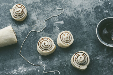 Raw, unbaked cinnamon buns resting. Cooking of healthy buns from alternative flours. Vegan bread. Festive food