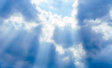 amazing blue cloudscape background with sun beams , clouds and sun rays streaming throught thr cloud