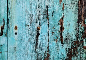 Close up old wood planks with worn blue paint and rusty nails texture background.