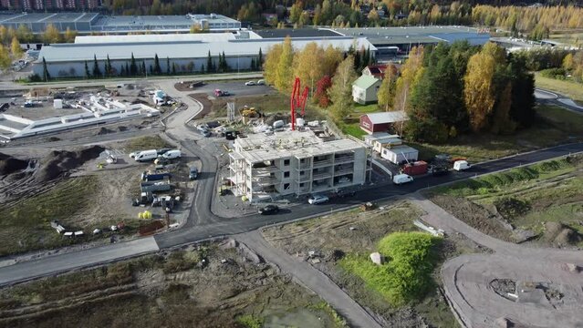 Aerial pulls back from concrete building under construction in Finland