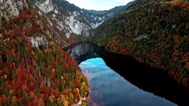 Drone shot overlooking stunning red foliage at Lake Toplitzsee, in Austria