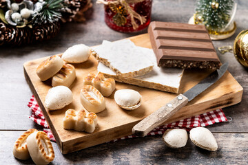 Fototapeta na wymiar Traditional Christmas sweet, nougat and Christmas sweet almonds on wooden table
