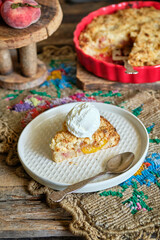 Peach and plum streusel pie with ice cream, side view, wooden background, rustic.