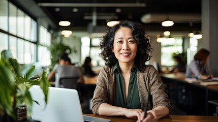 Middle aged Asian woman in a coworking with copy space