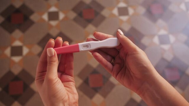 Woman with anxious feelings. Girl with a negative pregnancy test. Close-up of hands holding pregnancy test.