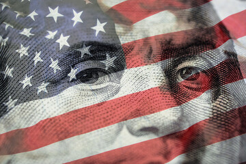 Closeup Benjamin Franklin face on USD banknote with USA flag and stock market chart graph for...