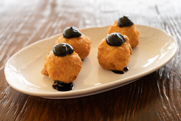 Close-up of a tapa of small croquettes with squid ink
