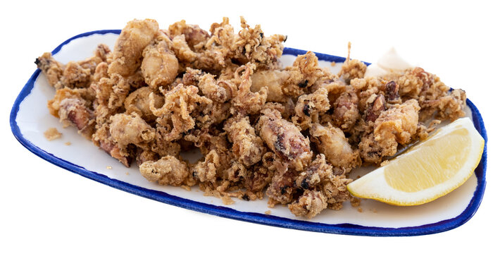 Spanish tapa of small squid in batter fried with lemon on a white background with copy space on the side. Spanish cuisine concept. Transparent background
