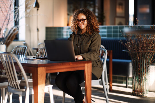 Smiling businesswoman working on a laptop in an office lounge