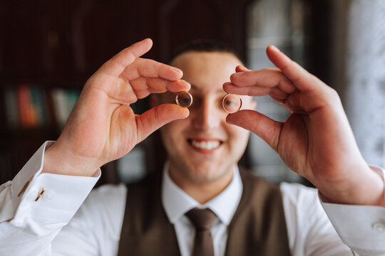 Groom holds wedding rings. blurred photo. Business style