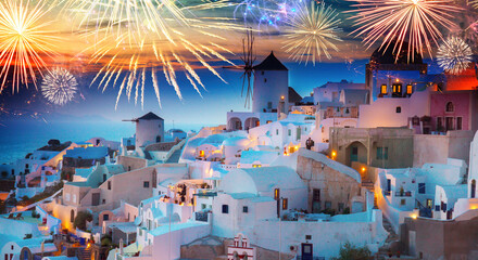 lights of Oia village at night with fireworks, Santorini, Greece