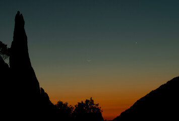 La luna crescente brilla nel cielo al tramonto, accompagnata dal gigante gassoso Giove. La scena è...