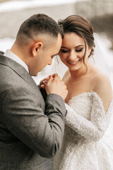 The groom holds the bride's hands. Sincere emotions. A walk in the forest. Winter wedding